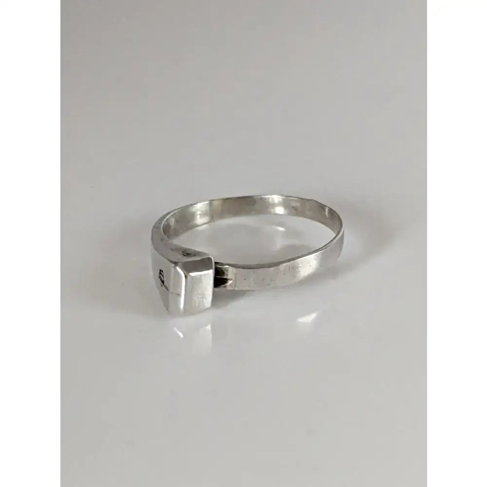 A sleek silver hoof nail ring with a rectangular faceted stone handmade as an equestrian gift for him or her