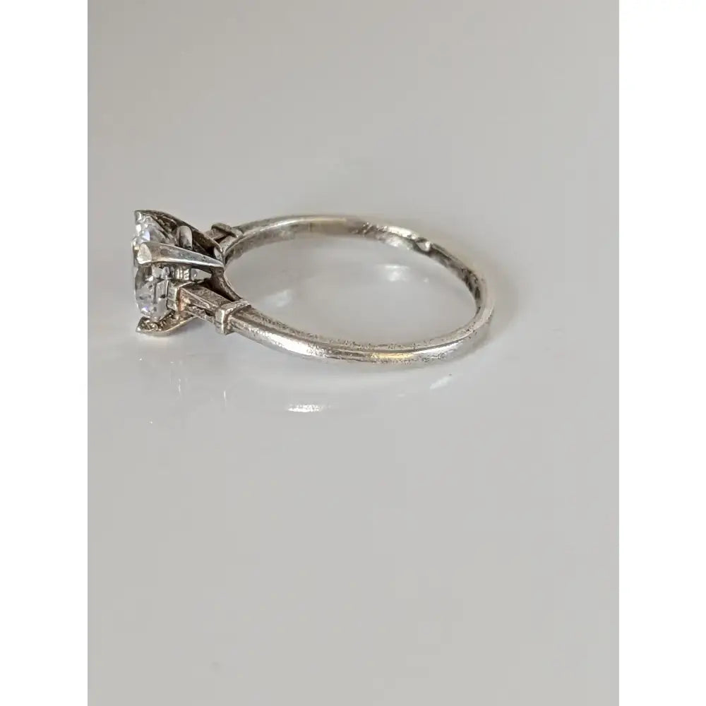 Vintage-style platinum engagement ring with a round-cut diamond and slender band showing subtle wear for elegant sparkle