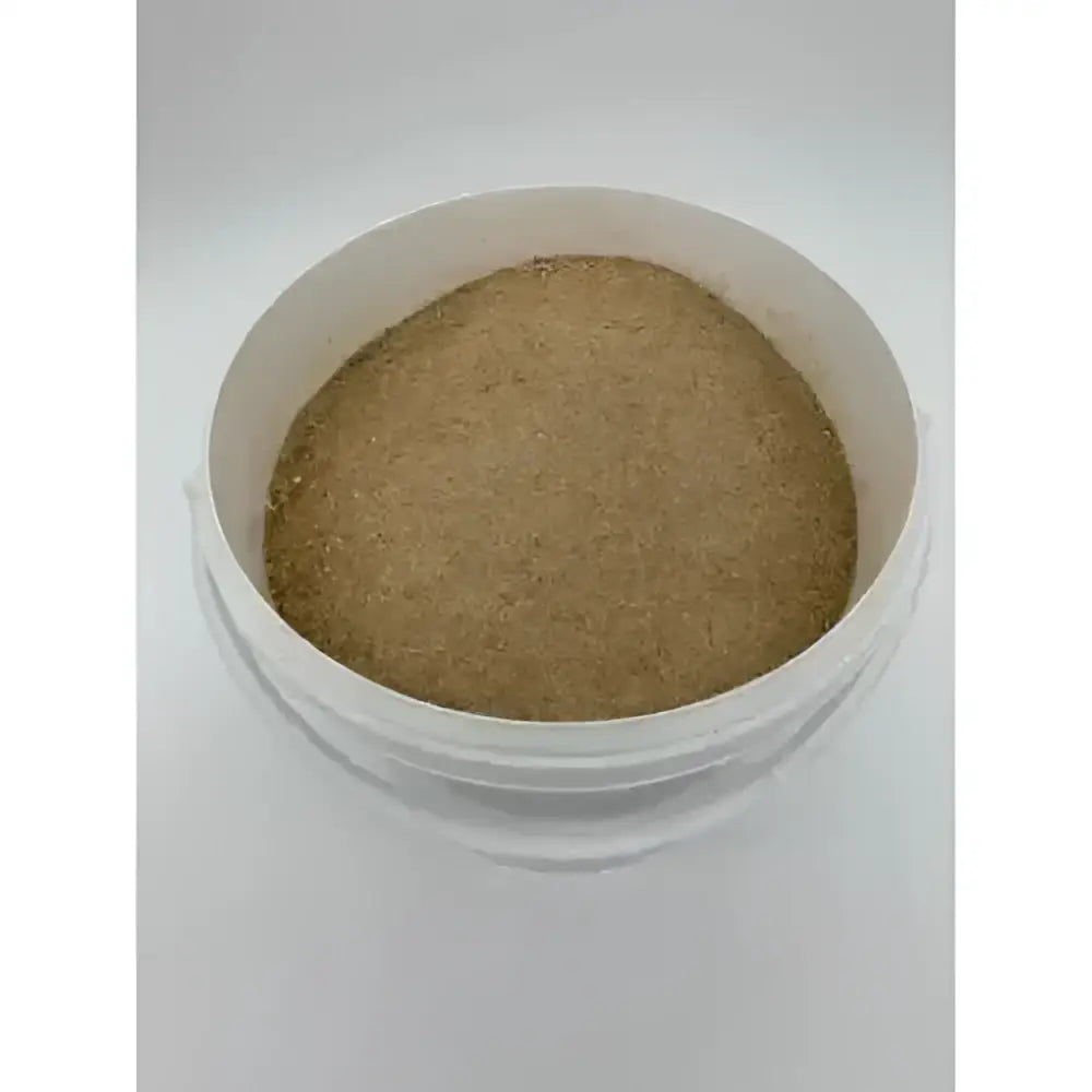 A white plastic container with light brown granular caprivite vitamin mineral feed supplement for goats with unique apple flavouring