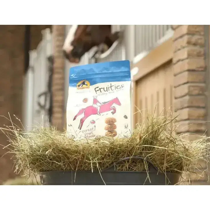 A blue and white bag of cavalor fruities horse treats with a pink cartoon horse design for healthy horse snacks