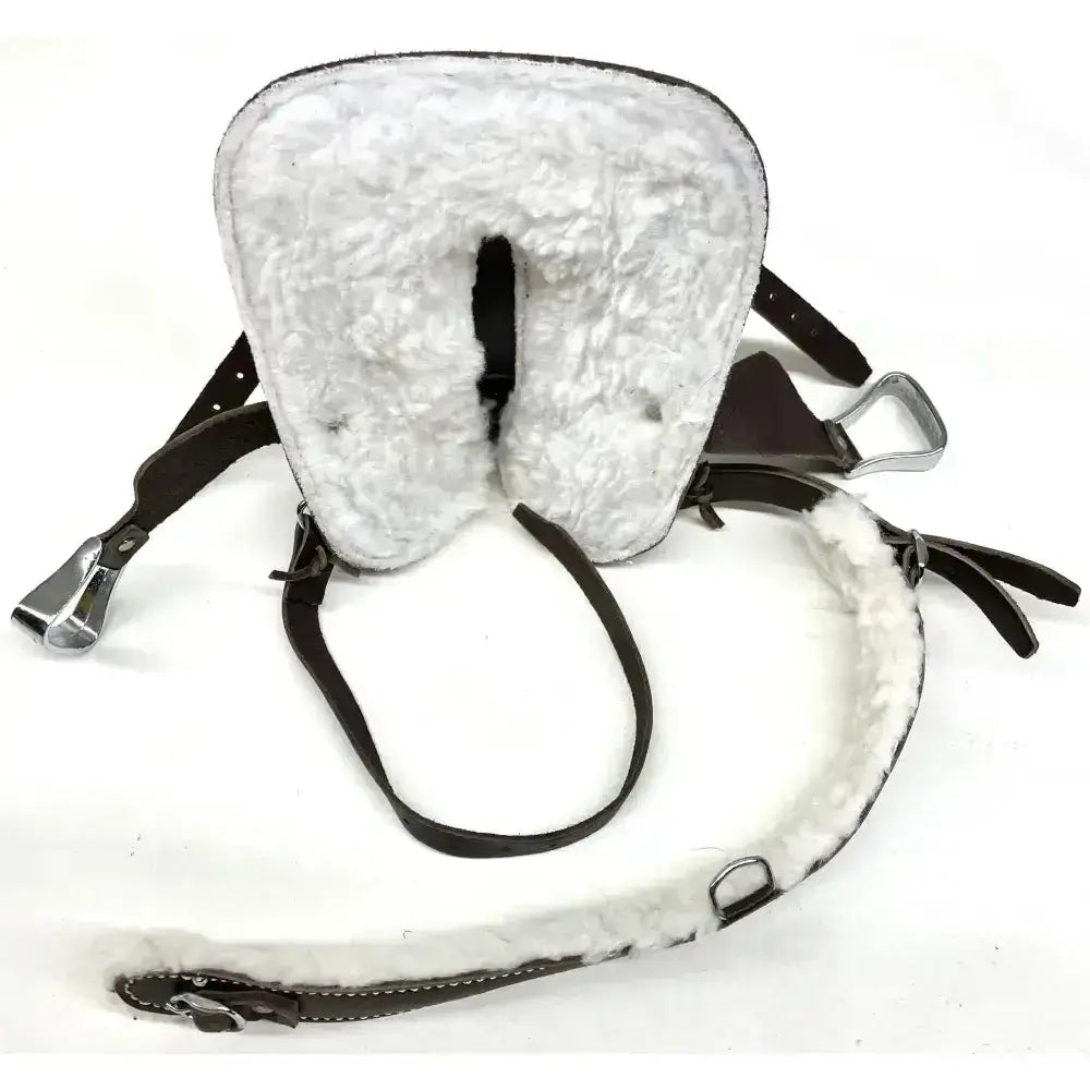 White sheepskin-lined horse saddle pad with dark brown leather straps and silver stirrup leathers in crafty ponies western tack starter set
