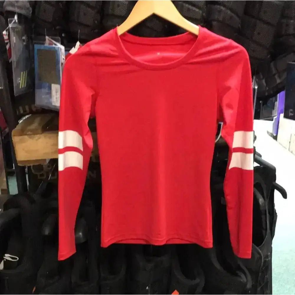 Red long-sleeved cross country top with white strips on sleeves hanging on wooden hanger perfect for equestrian use
