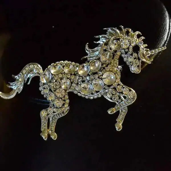 A sparkling silver effect prancing unicorn brooch with clear and pale yellow rhinestones details