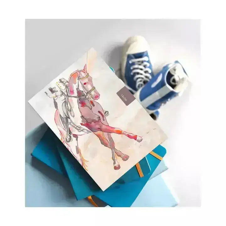 A pink watercolor dressage horse in motion on a deckled edge notebook perfect for pocket sized notebooks