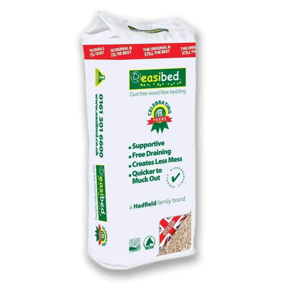 A white easibed pet bedding bag with dust free wood fibre bedding featuring green red branding and a 15-year anniversary logo