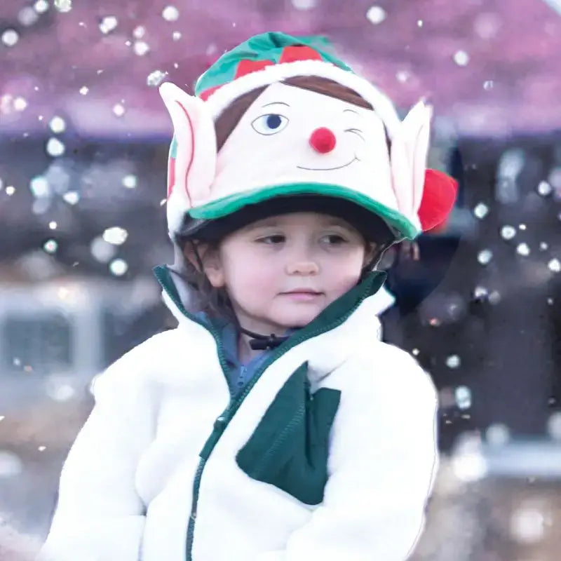 A child wearing the equetech cheeky elf silk hat in green and white with embroidered eyes, red nose, and pointed ears
