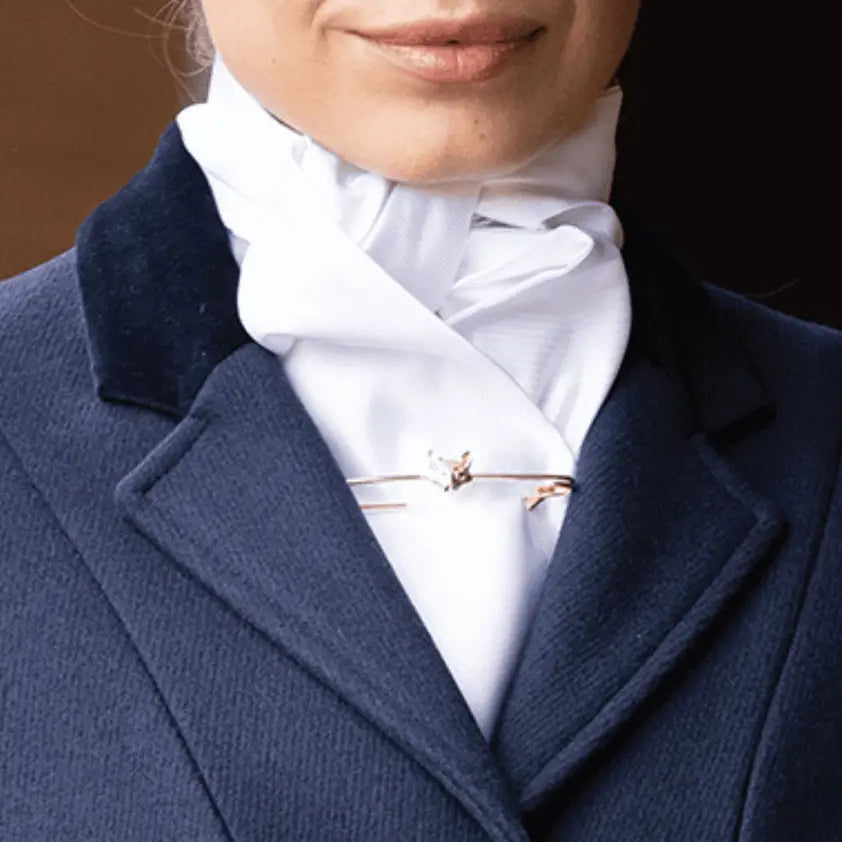A delicate rose gold fox-shaped stock pin with gemstones on a white equetech marcella cord cotton marcella stock