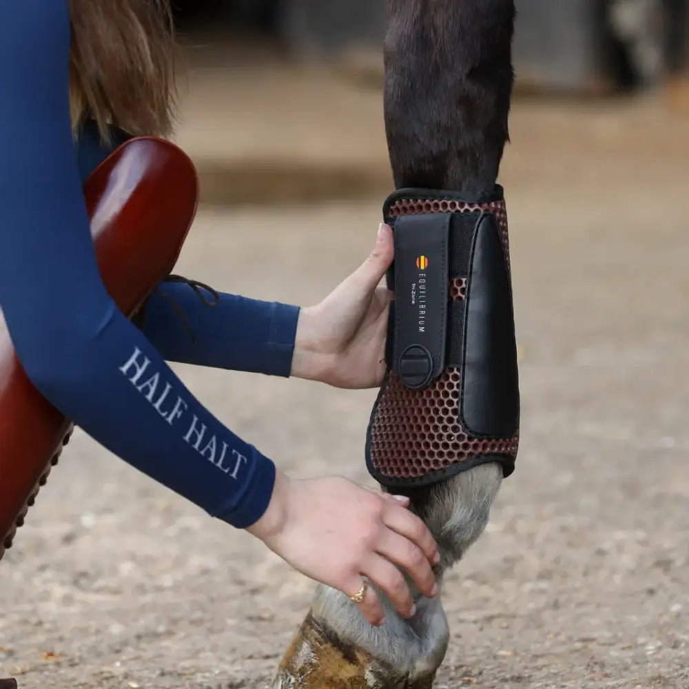 Black equilibrium tendon boots brown featuring red mesh and a digital control panel for hoof protection