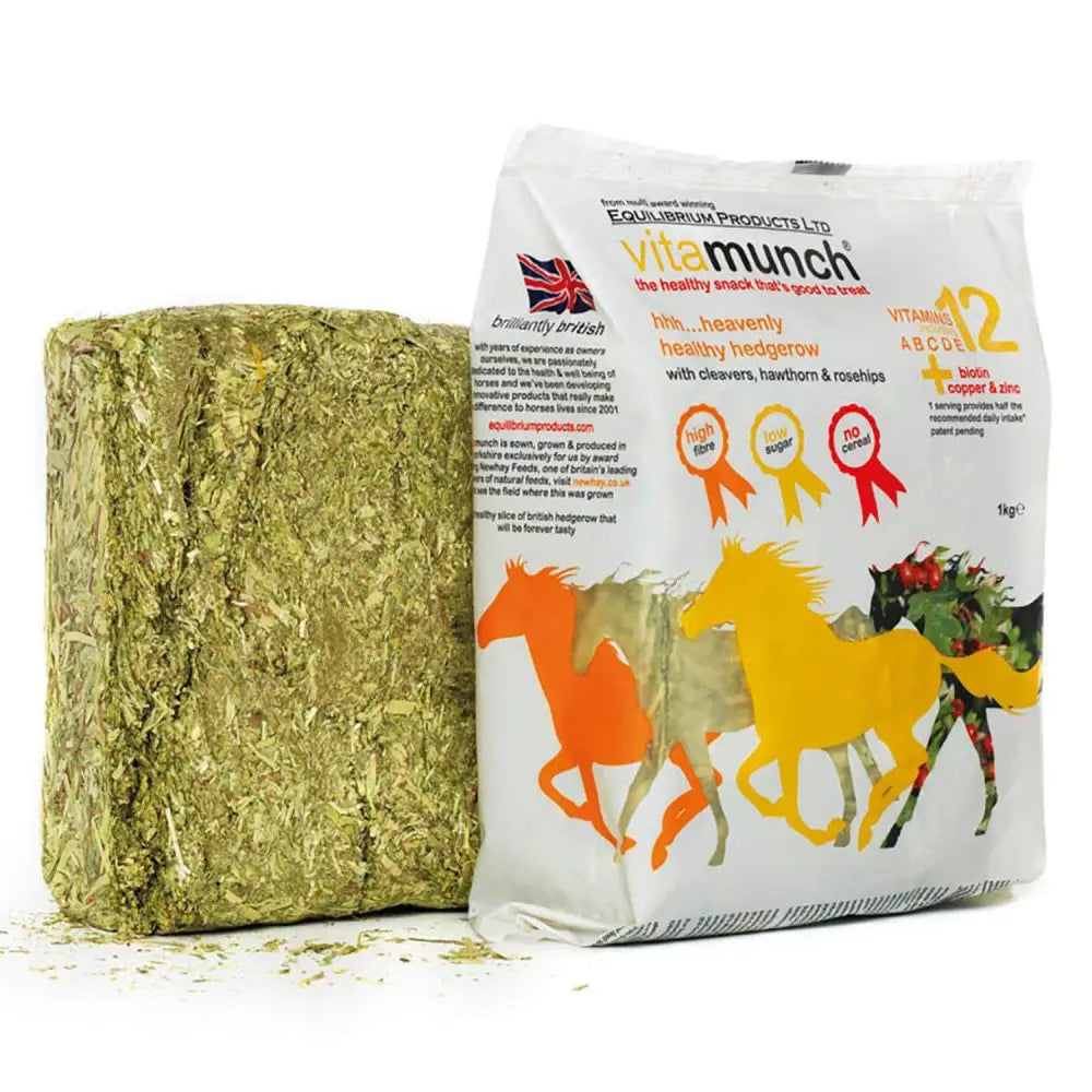 A rectangular block of green textured heavenly hedgerow hay with a white vitamunch bag beside it for small pets