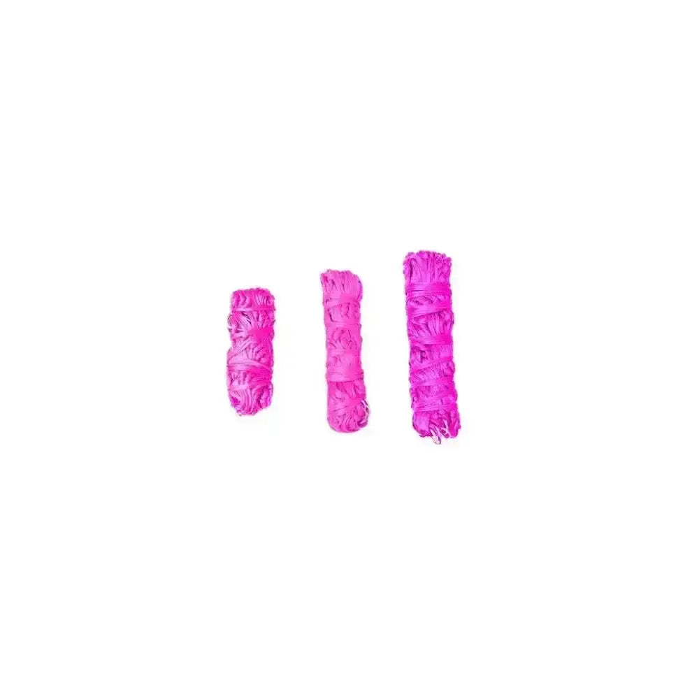 Three vibrant pink sage smudge sticks with fibrous texture tied at top shown alongside gallop small haynet for horse feed