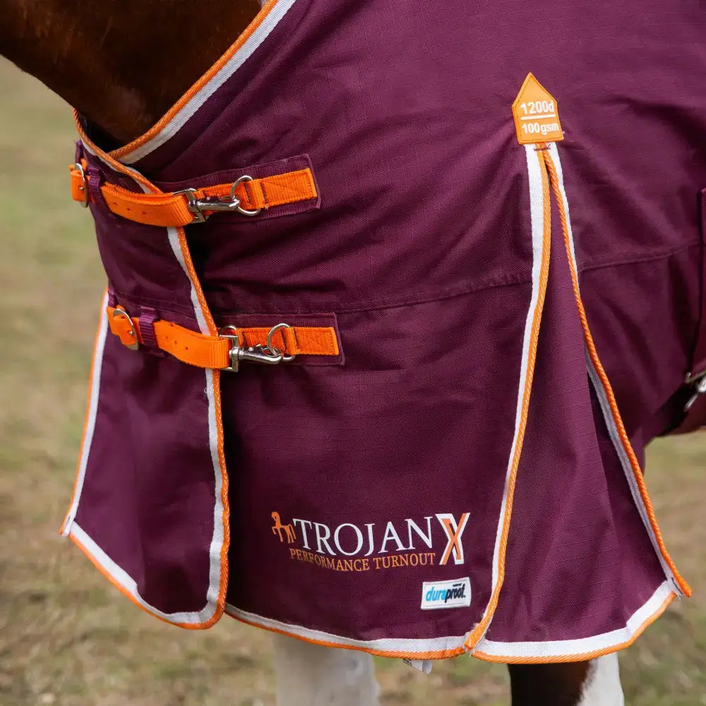 A maroon gallop trojan xtra duraproof 100g lightweight turnout rug with orange and white trim and adjustable straps