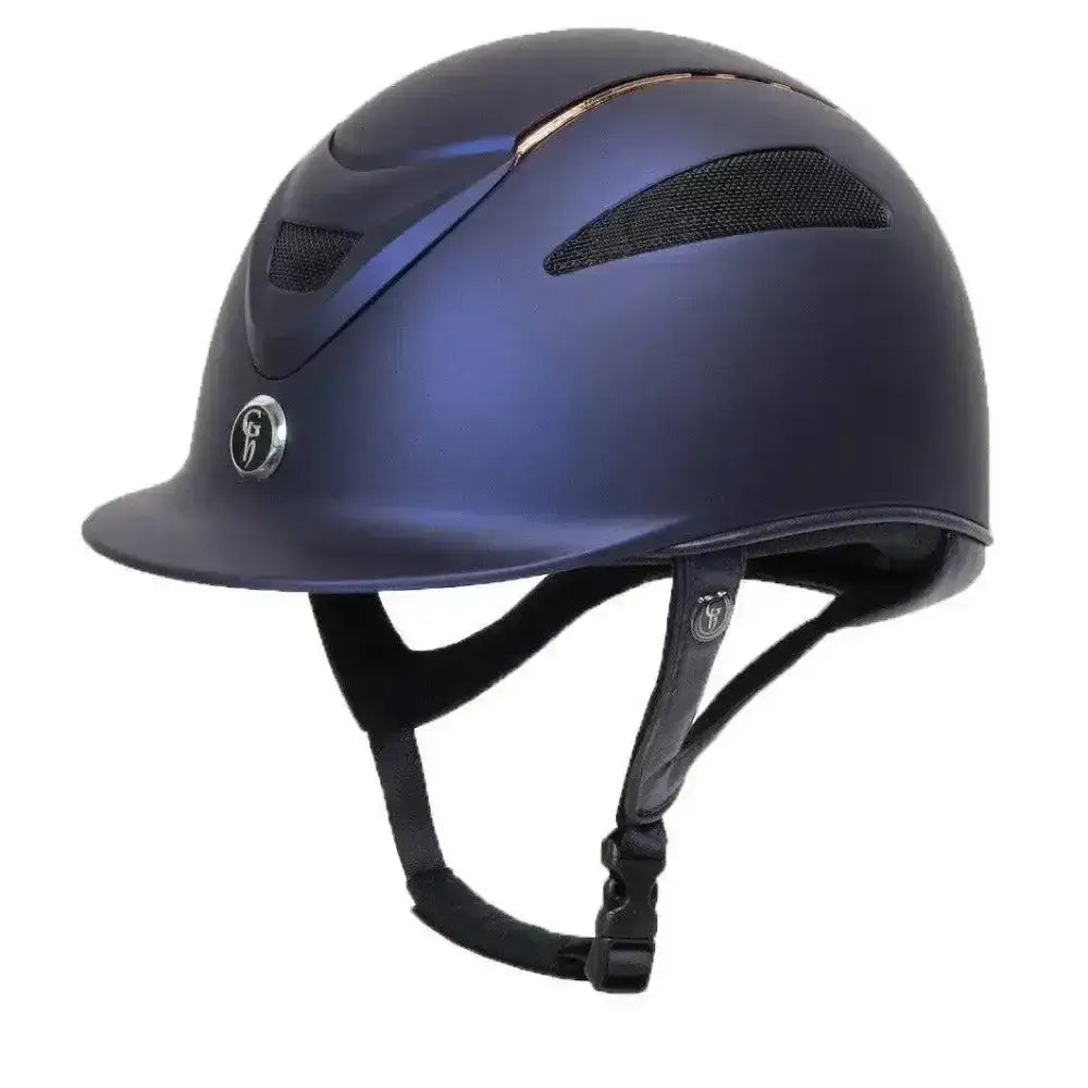 A sleek matte navy blue gatehouse conquest mark peaked riding hat with black vents and a rose gold limited edition logo emblem