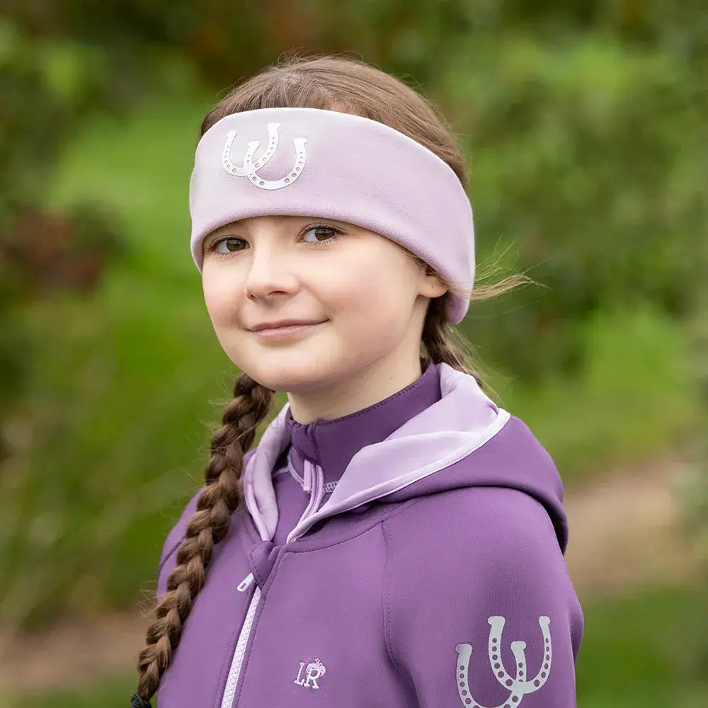 A soft lavender gymkhana headband by little rider with a silver horseshoe emblem perfect for equestrian horses fans