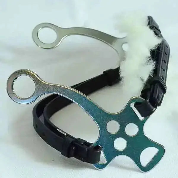 Black leather english leather hackamore with green metal bit featuring circular cutouts and white sheepskin noseband padding