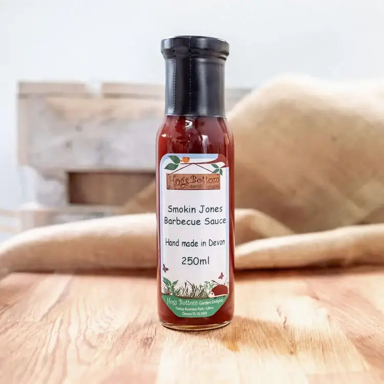 A glass bottle of hogs bottom smokin jones bbq sauce 250ml with rich red sauce and green accented label