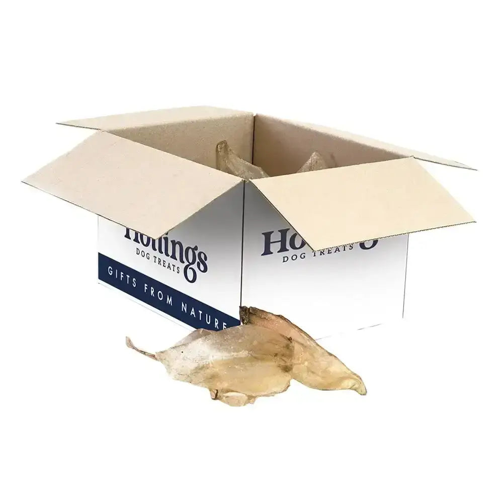 Open cardboard box of hollings cow ears dog treats with white and navy label for healthy longer lasting chew natural cows ears