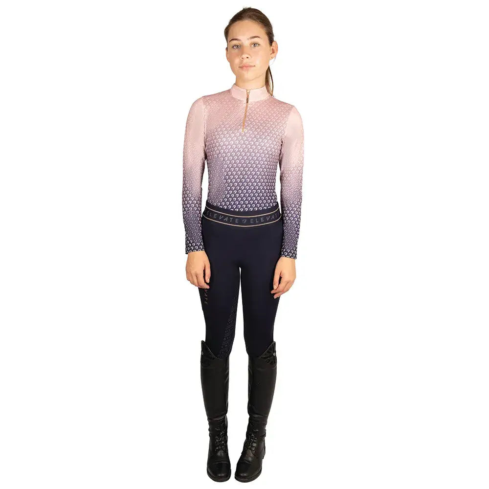 A woman wearing a long-sleeved gradient pink to purple hy equestrian elevate allure mizs ombre base layer top