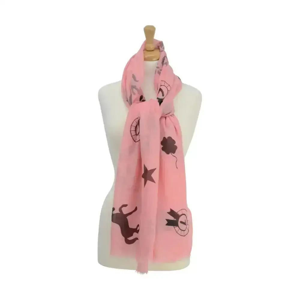 A soft pink HY equestrian ladies balmoral scarf with black stars clovers whimsical animals and horse shoe patterns