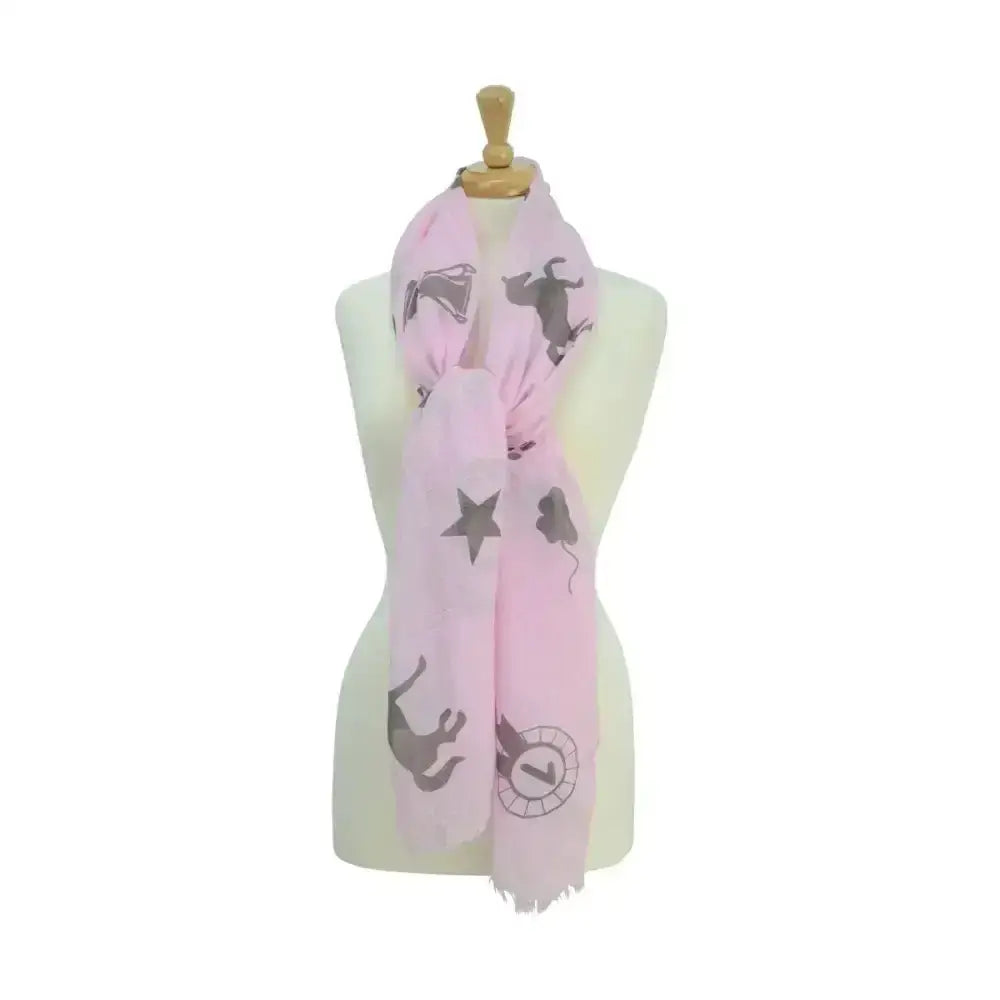 A soft pink equestrian ladies balmoral scarf with playful grey cats stars clock faces and horseshoe patterns