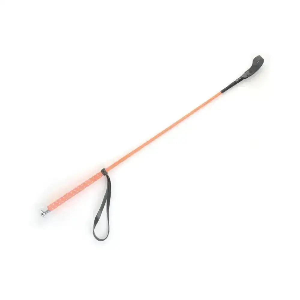 A sleek peach neon riding whip with black leather grip and silver fleck handle perfect for equestrian use