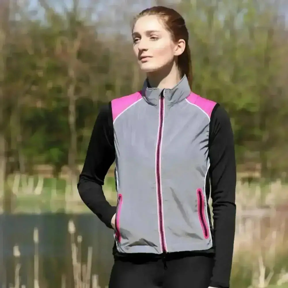 Gray and pink hy equestrian silva flash two tone reflective gilet layered over black long sleeves for riding comfort