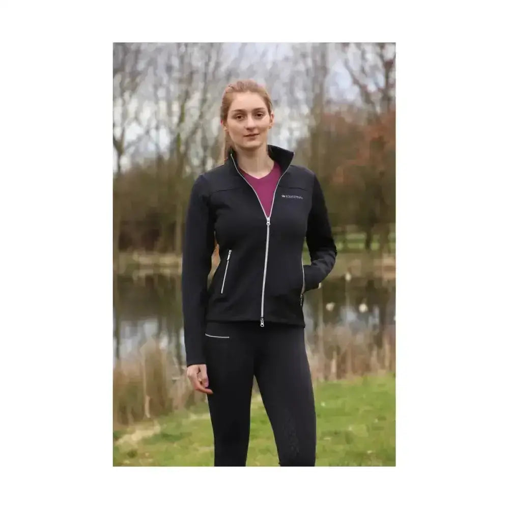 Black zip-up jacket with white zipper and trim featuring subtle logo designed to allow unrestricted movement for synergy riding tights