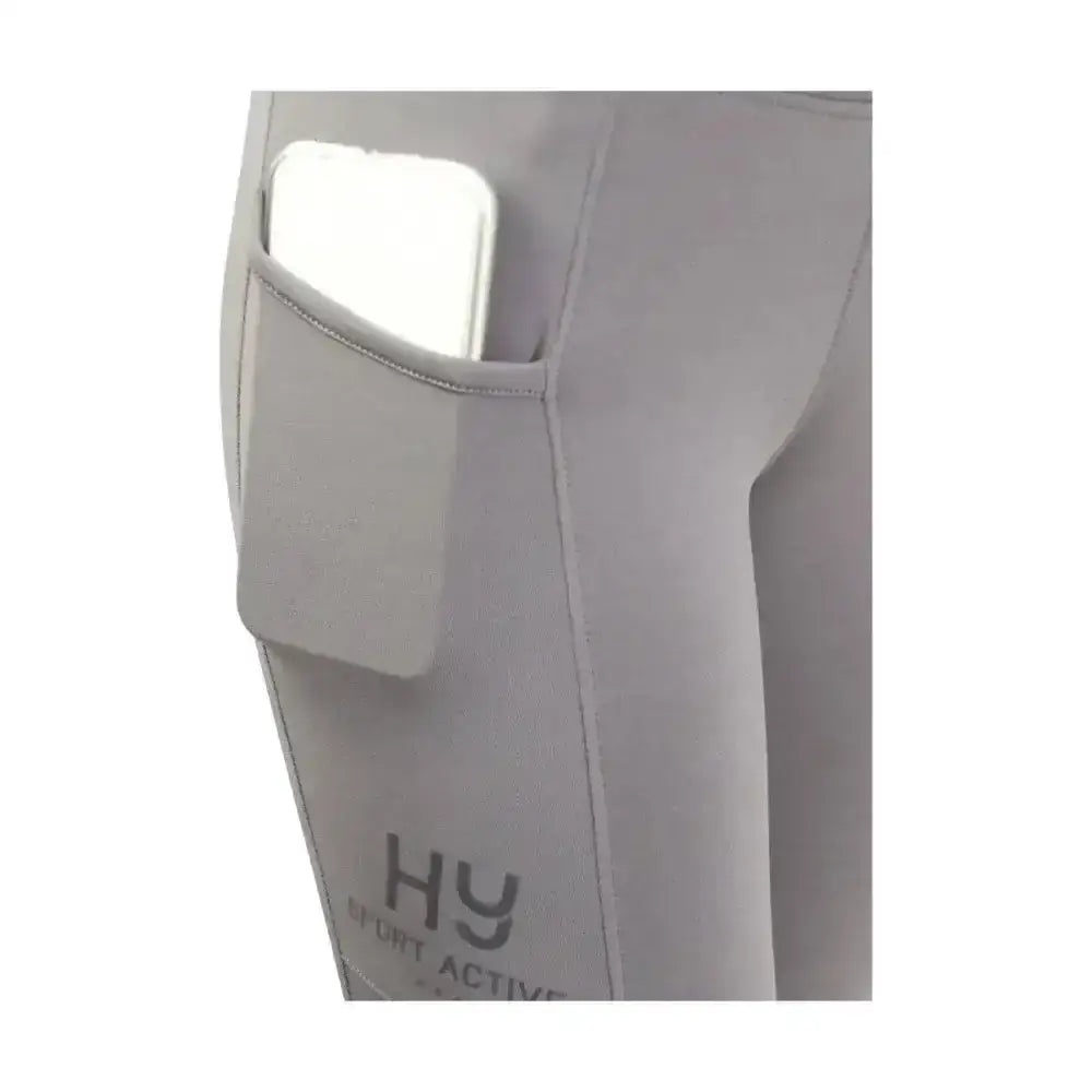 Gray hy sport active riding tights with wide stretch waistband and side pocket holding a white phone
