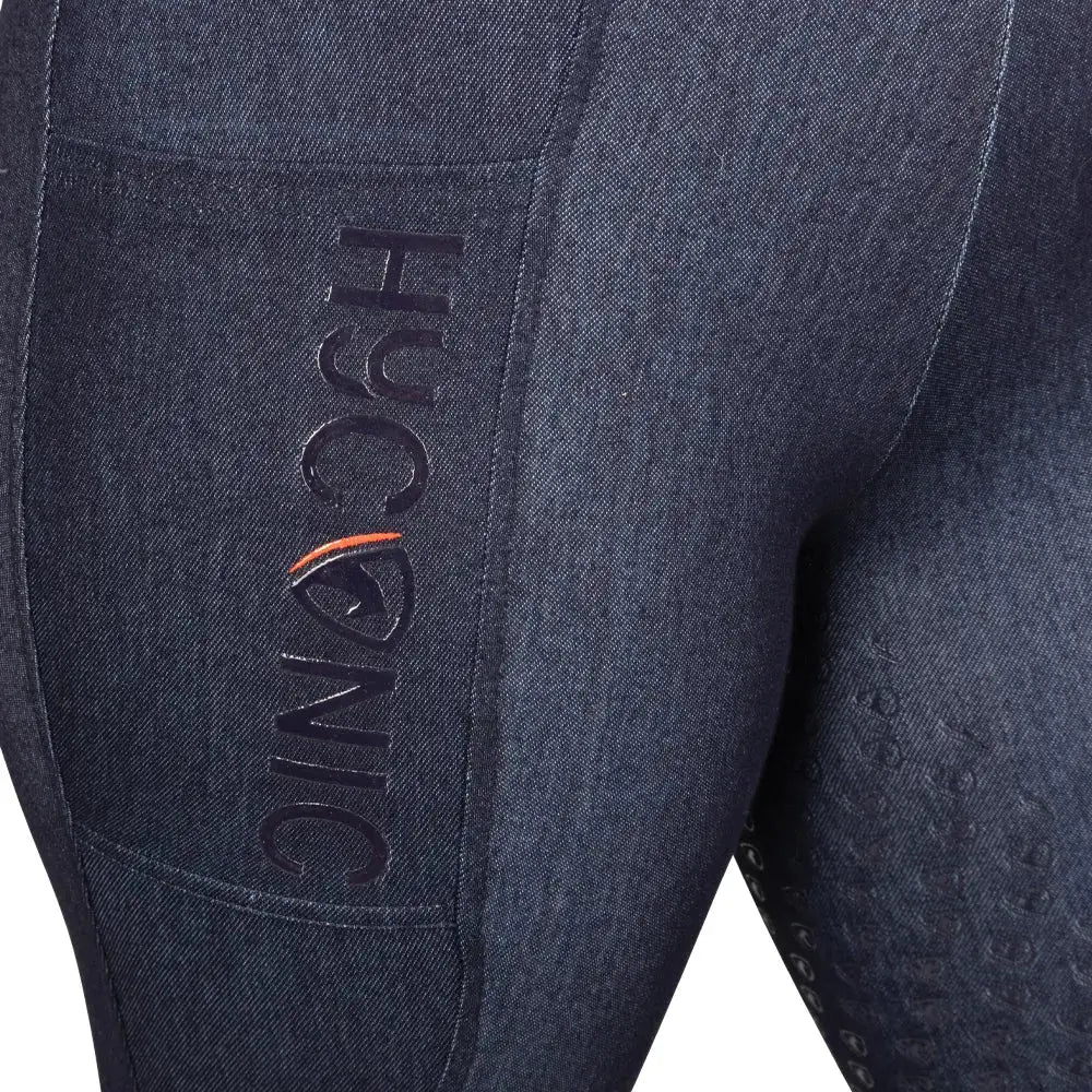 Dark blue denim hyconic valloria denim riding tights with subtle embossed logo and orange accent line for riding use