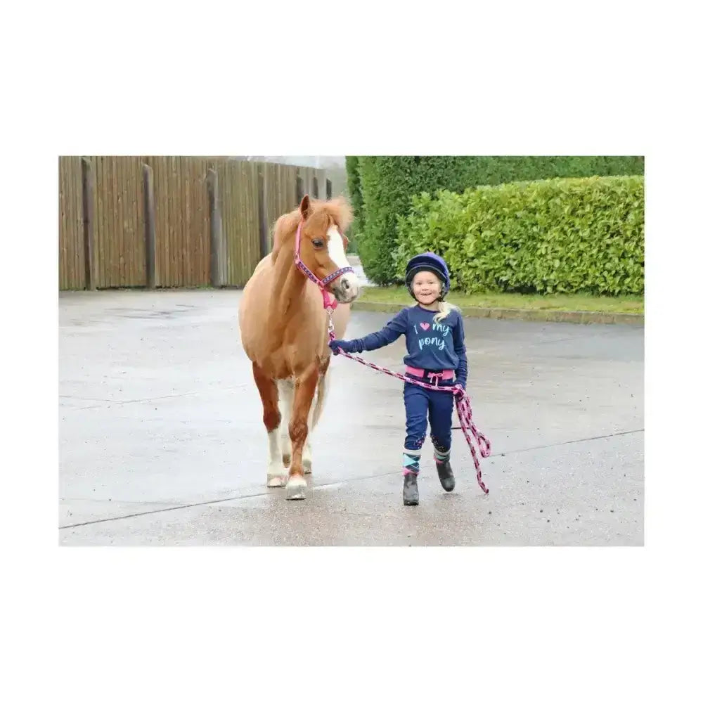 A young child wearing navy blue i love my pony shirt and pants with boots showcasing the little rider pony collection hat cover