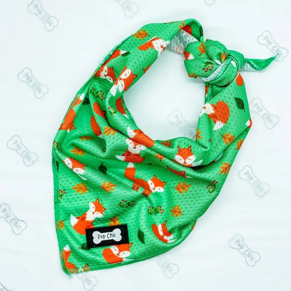 Green fox-patterned dog bandana with lighter green stitching and orange white accents from inquisitive fox cooling bandana