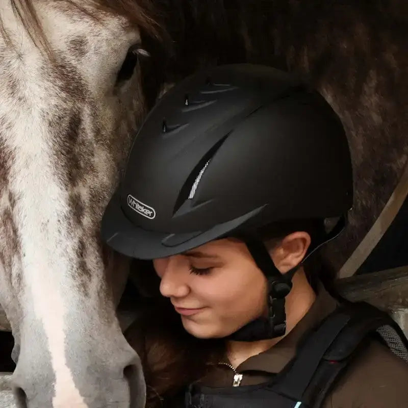 Black matte john whitaker nrg riding helmet rh040 adjustable with silver stripes and visible brand logo on the side