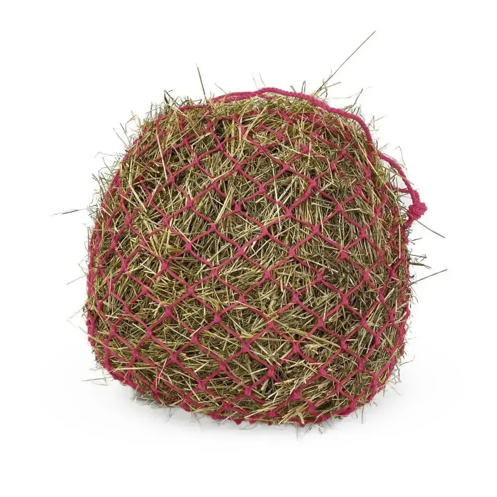 A round hay bale wrapped in a red mesh km elite deluxe haynet made of extra strong polyethylene for durability