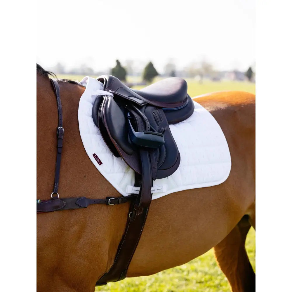 White quilted lemieux 3d mesh eurojump square white saddle pad with fabric weave under black equestrian saddle