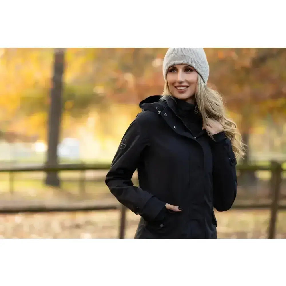 Black hooded lemieux amelie waterproof lightweight riding coat with subtle logo and zippered pockets