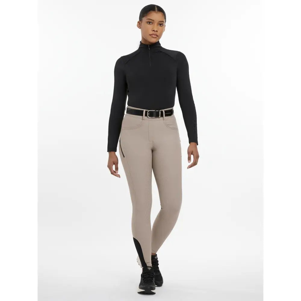 Beige lemieux amy breggings pecan riding pants with black side panels and a zipper pocket for equestrian use