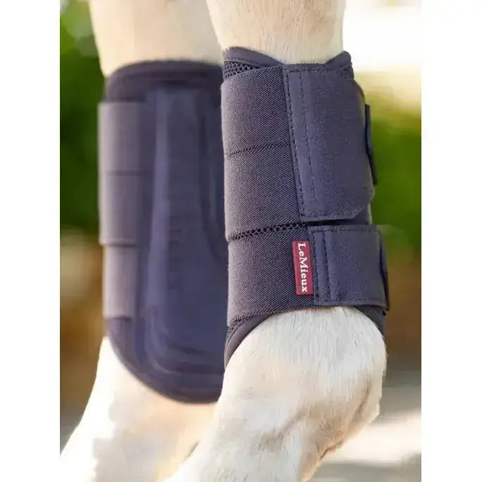 Dark blue lemieux arika mesh brushing boots dusk blue with adjustable straps and red brand tag on horse leg wrap
