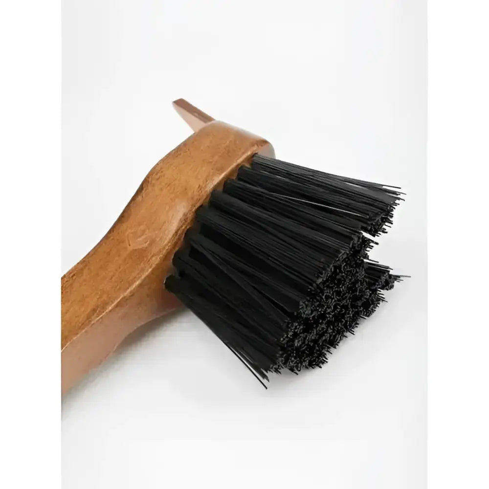 A lemieux artisan hoof pick with a sturdy wooden handle and dense black bristles for removing packed mud