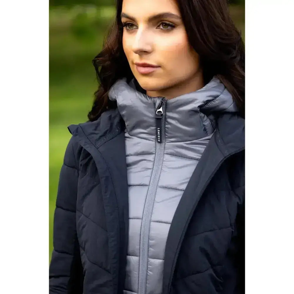 Dark navy quilted lemieux brioney hybrid jacket with gray puffer inner layer and branded zipper pull for cold weather