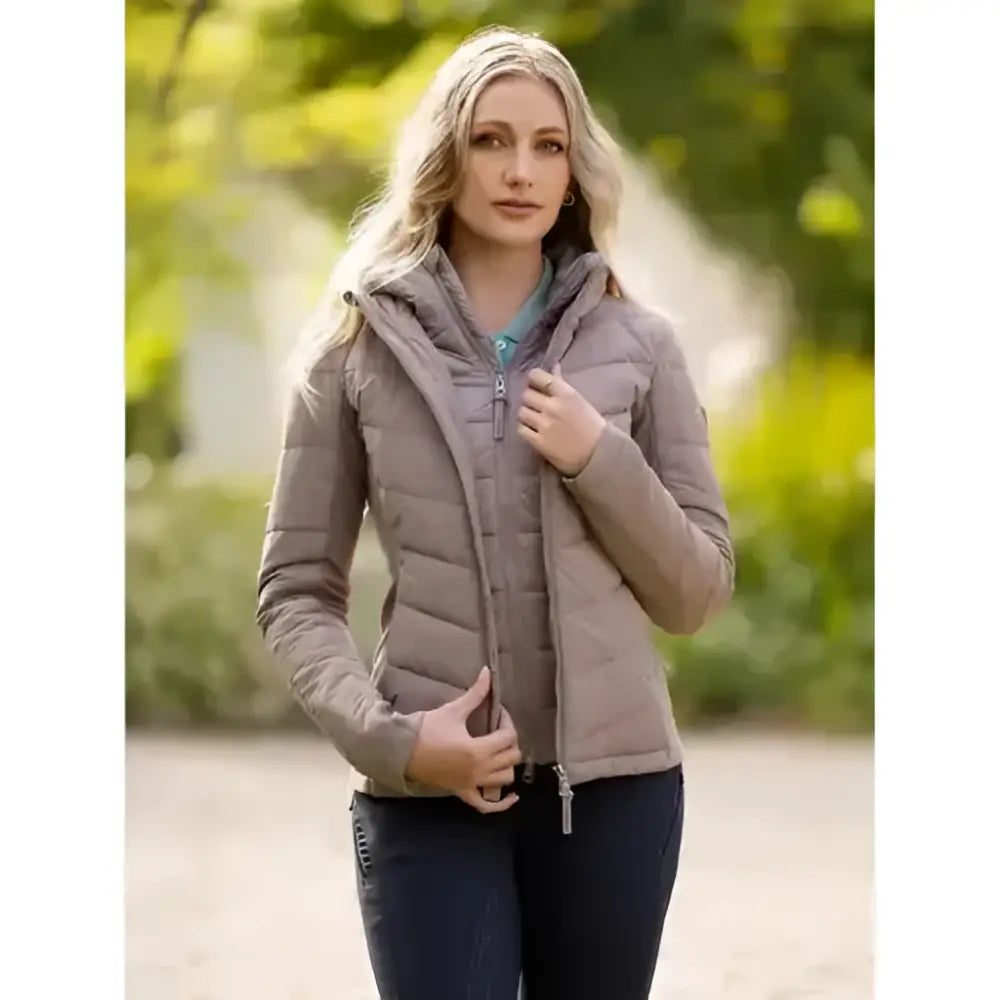 A woman wearing a lemieux pecan brioney hybrid jacket in beige with quilted hood panel and zipper closure