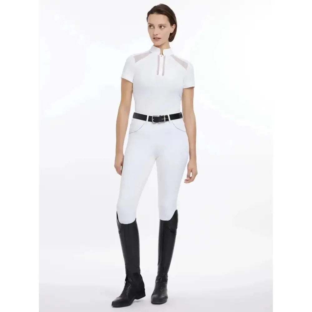 White equestrian riding pants with black belt and boots paired with lemieux camille short sleeve breathable lace mesh cut outs shirt