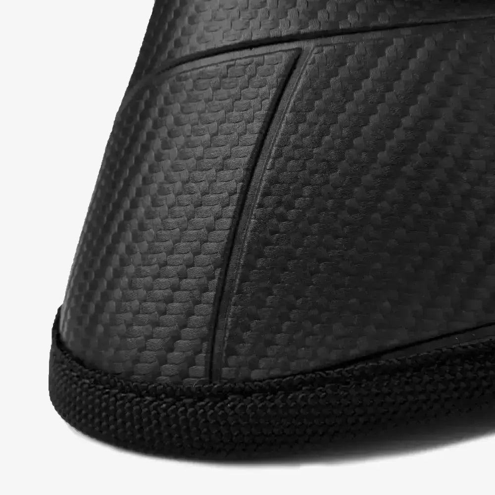Black carbon fiber-textured sole with rubber tread on back of lemieux carbonite over reach boots with strong ballistic outer