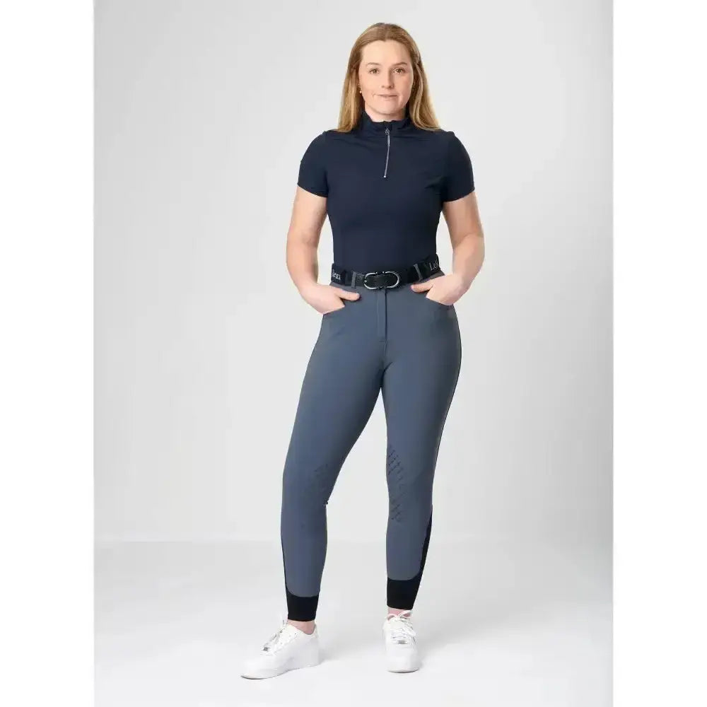 Navy blue short-sleeved equestrian top with half-zip collar and black belt paired with lemieux dynamique knee grip breeches ice grey