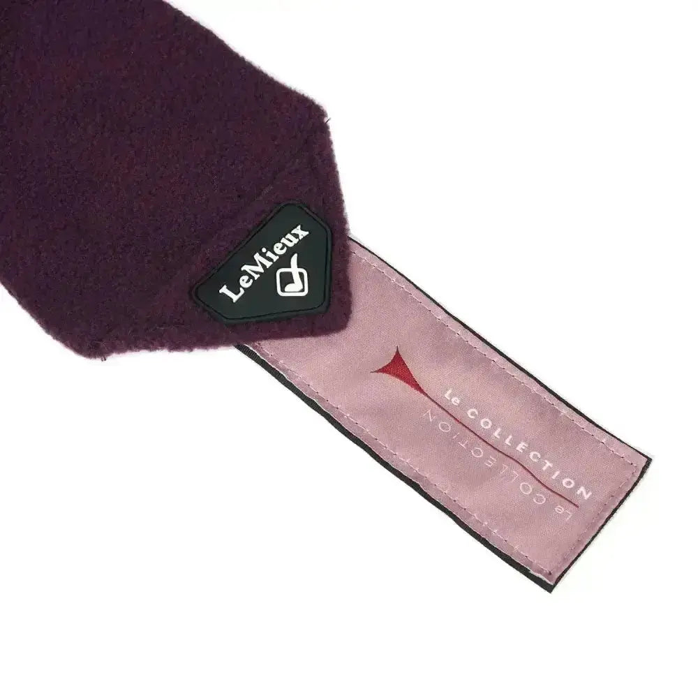A plush deep purple lemieux fig classic scarf with soft textured fabric and a luxury lemieux fleece branded tag