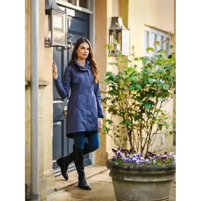 A navy blue lemieux grace long rain jacket dusk with a high collar and subtle front pockets perfect for rainy days