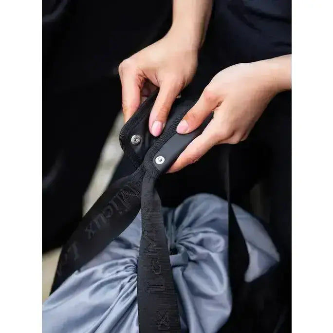 Black nylon strap with silver metal hardware and embossed branding on lemieux grooming tote black easy access grab-and-go bag
