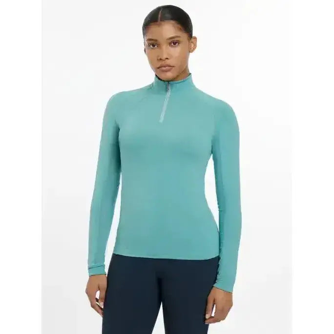 Teal long-sleeved lemieux halle lightweight base layer lagoon with quarter-zip neckline for active wear