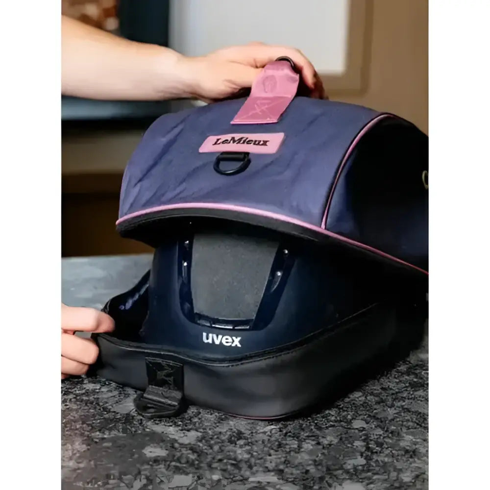 A navy blue and black lemieux hat box dusk blue box with pink trim designed to hold a uvex helmet