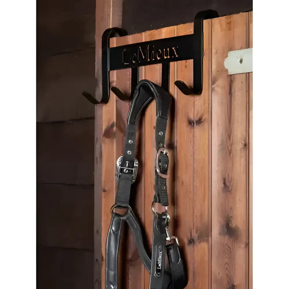Black metal lemieux headcollar hanger holding a black leather lemieux headcollar headcollar hanger black