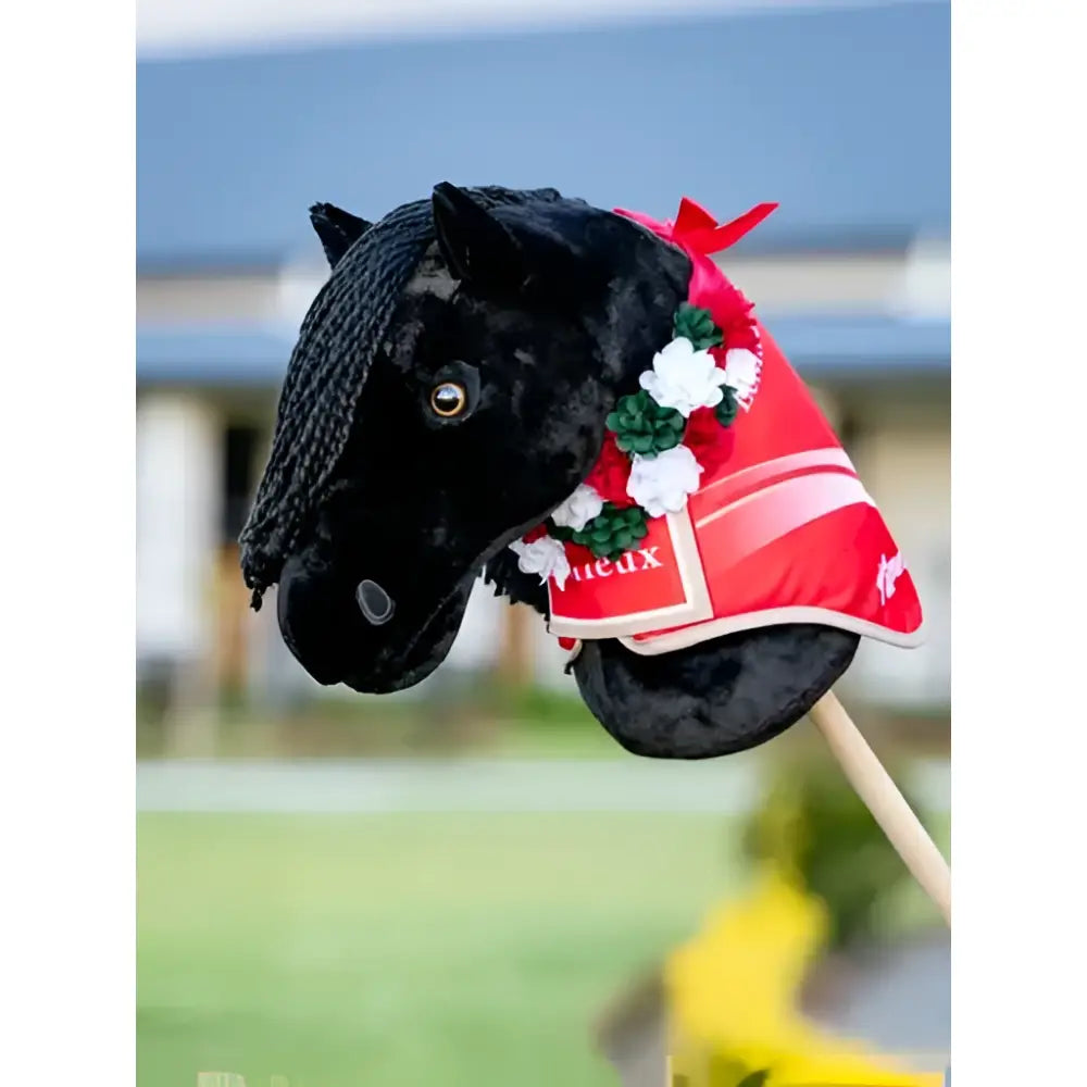Black plush lemieux hobby horse with red and white flower sash red decorative blanket and floral accents