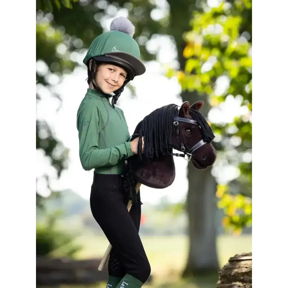 Green lemieux hobby horse equestrian helmet with gray brim and white pom pom in hobby horse freya style